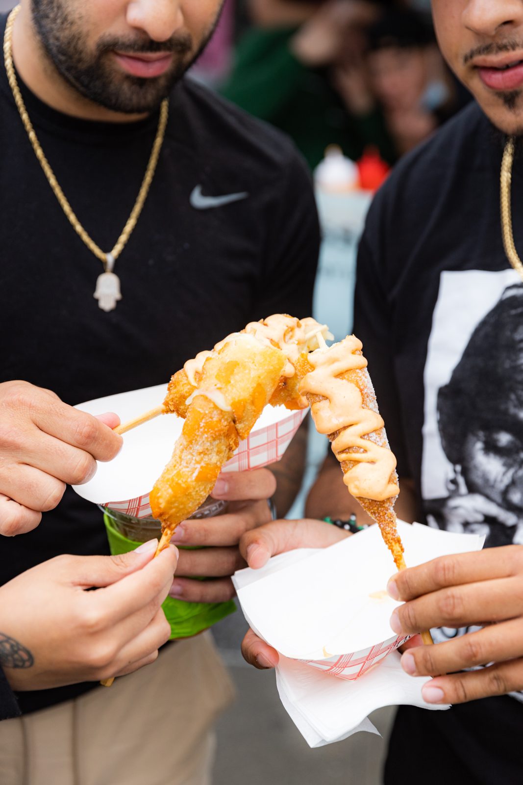 Two attendees with battered corn dogs