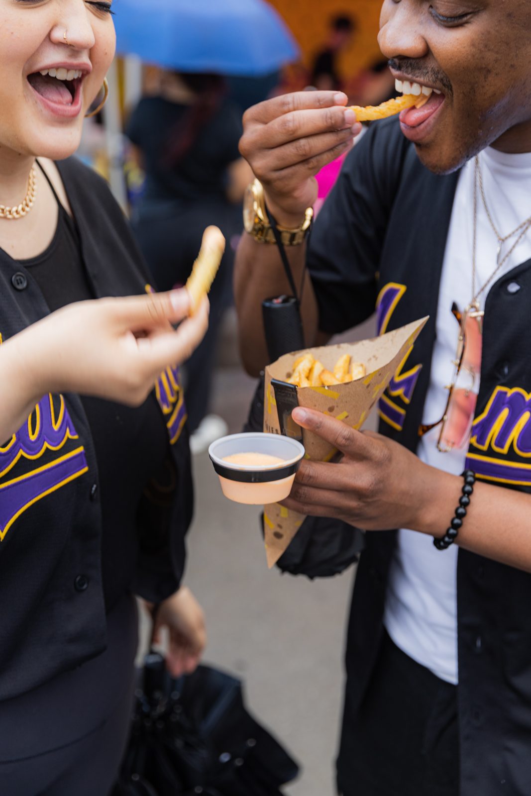 Two friends sharing fries at Bronx Night Market