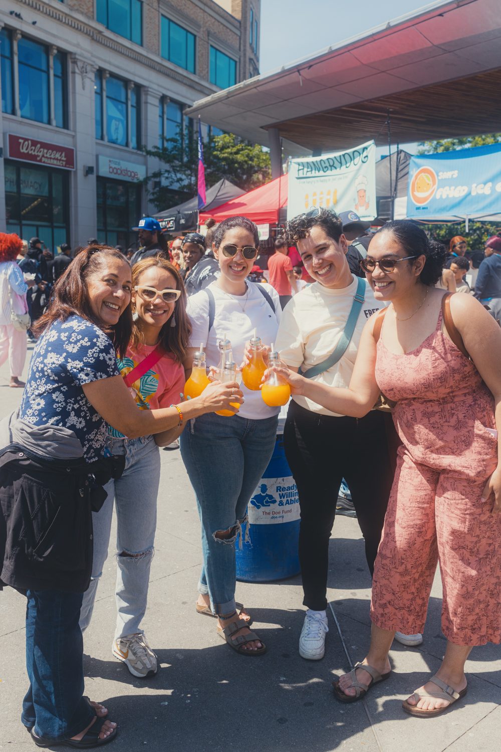 Friends toasting fresh juices at the market