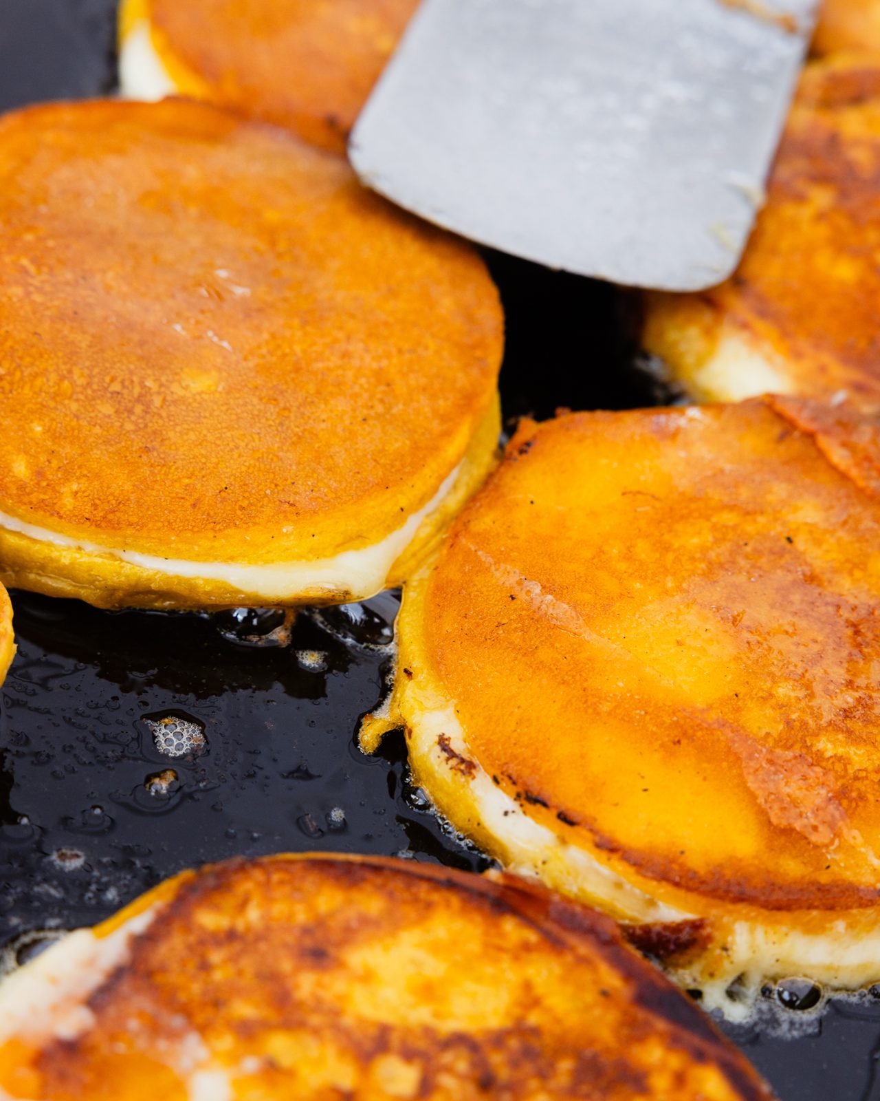 Cheese-filled arepas frying