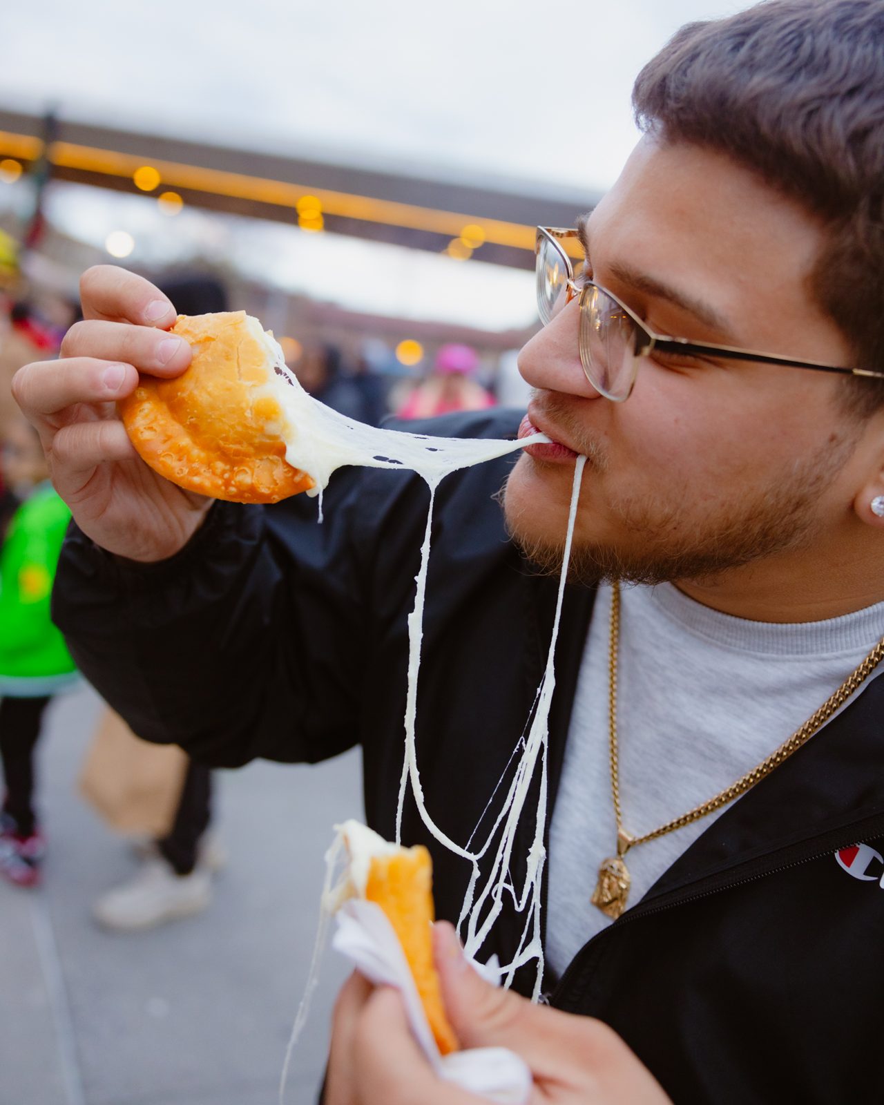 Attendee biting into a cheese empanada
