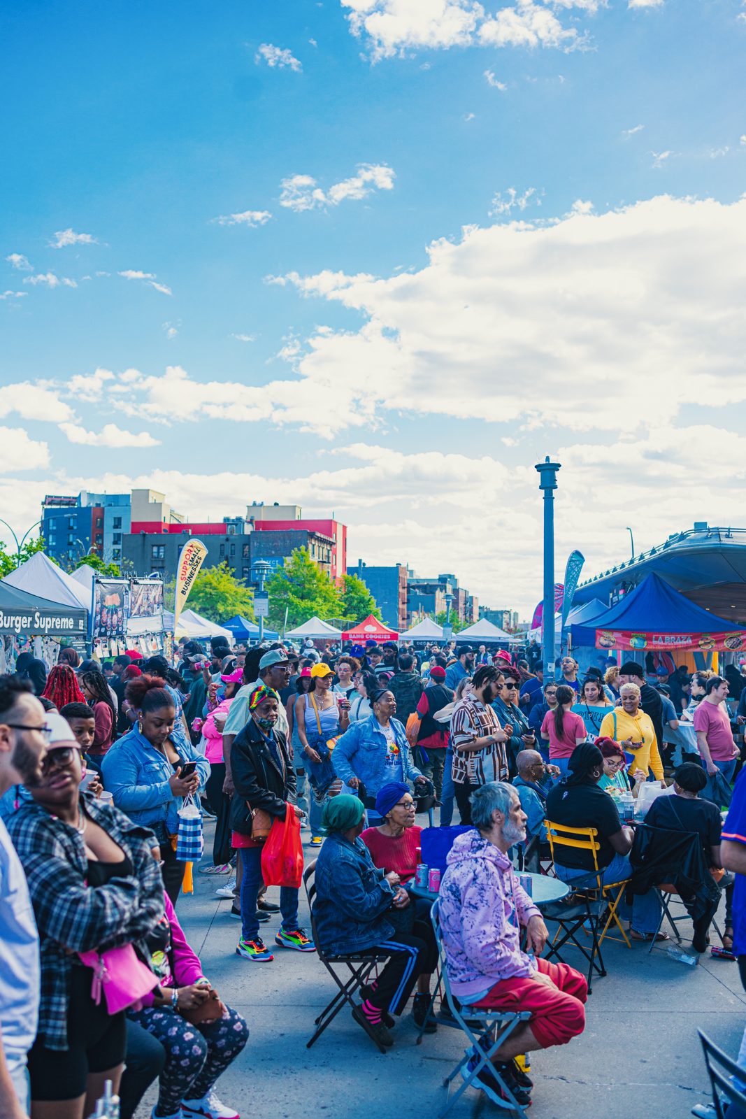 A packed Bronx Night Market crowd under blue sky